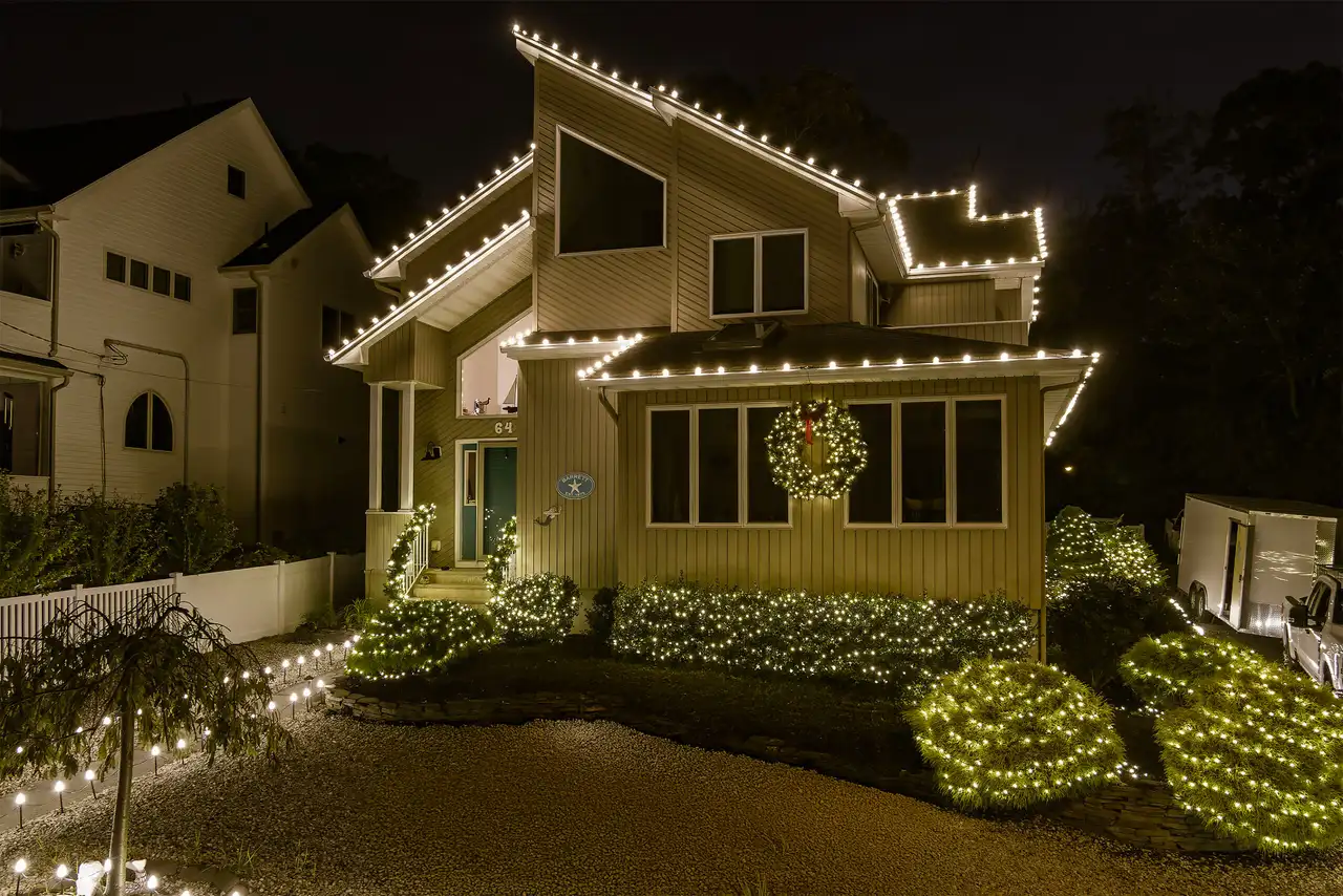 Home with holiday lights outlining the roof and windows at night